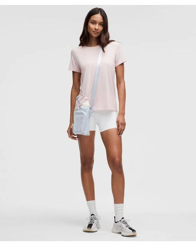 Mulher com Bolsa para Garrafa Térmica - Cross Bottle Lululemon, ideal para exercícios, caminhadas e uso urbano, em estilo leve e compacto.