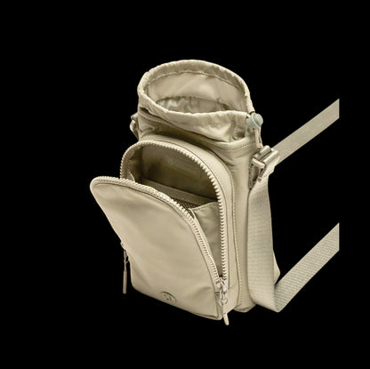 Bolsa para Garrafa Térmica - Cross Bottle Lululemon em cor neutra, compacta e funcional para transportar garrafas e pequenos objetos.