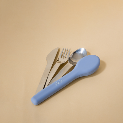 Kit de Talheres Pacco PocketSet de aço inoxidável com estojo em silicone azul sobre fundo bege.