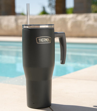 Thermos Copo Térmico Aruba com Canudo -1,1L de aço inoxidável, ideal para manter bebidas frias ou quentes, colocado em uma borda de piscina.